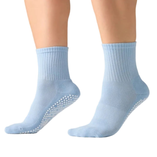 Light blue socks with non-slip sole on a neutral background