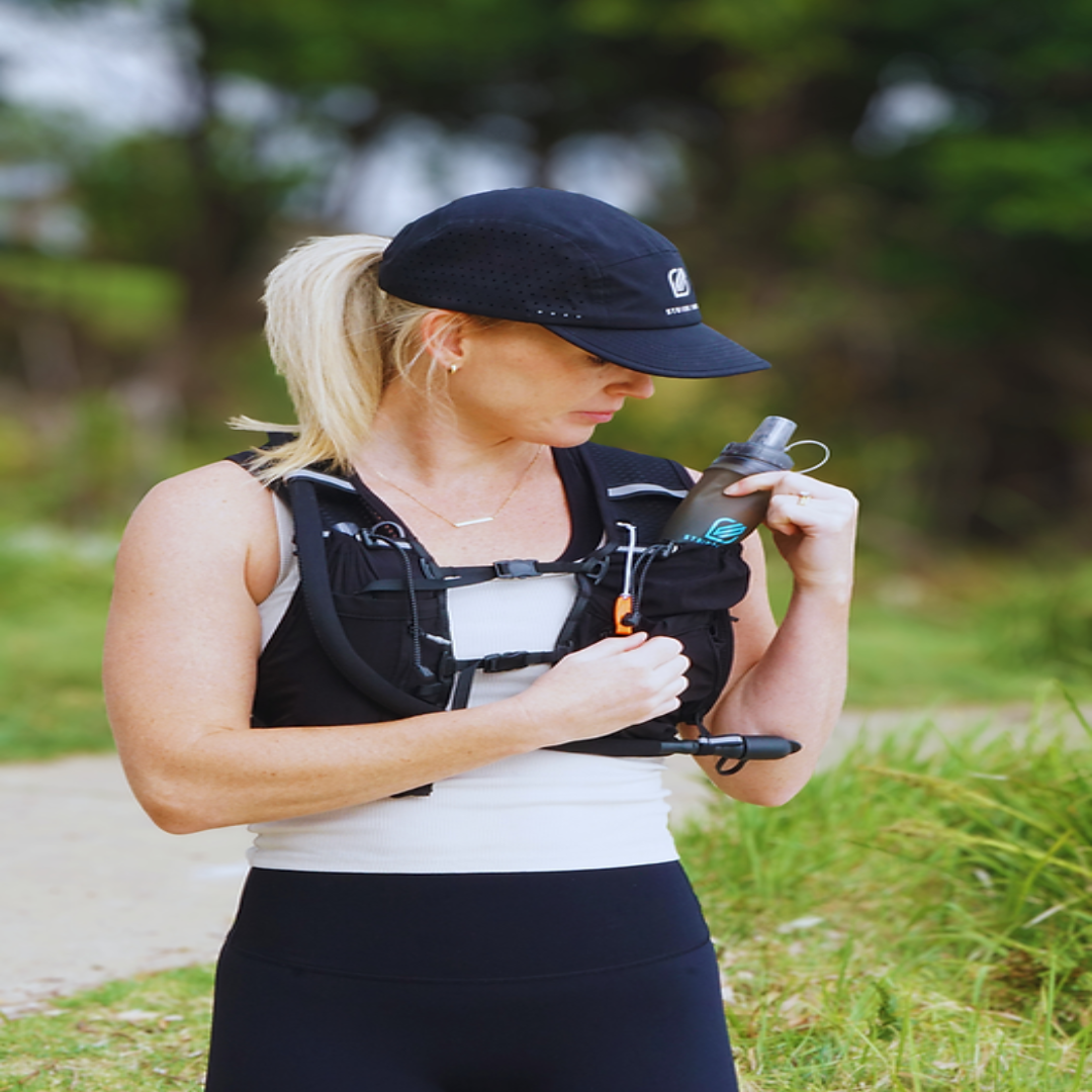 Woman in athletic wear with a water bottle holder outdoors